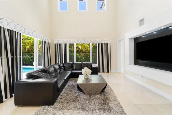 a living room with furniture tv and large window
