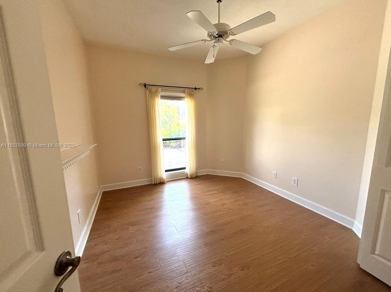 3356 North Bent Tree Point Lecanto, FL 34461 - Photo 14 of 25 an empty room with wooden floor fan and windows