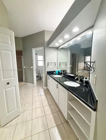 a kitchen with a sink a refrigerator and cabinets