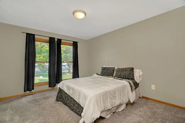 a bedroom with a bed and a large window