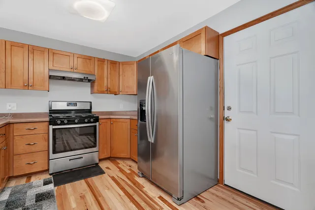 a kitchen with stainless steel appliances granite countertop a refrigerator and a stove