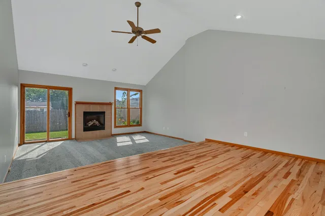 a view of empty room with wooden floor and fireplace