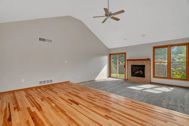 a view of an empty room with a fireplace and a window