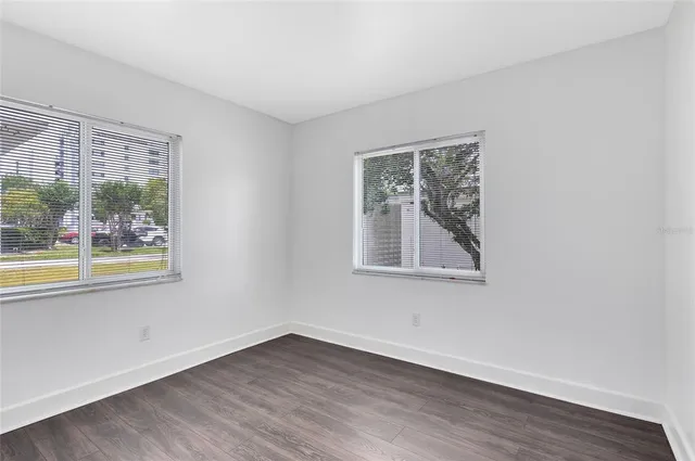 an empty room with wooden floor and a window