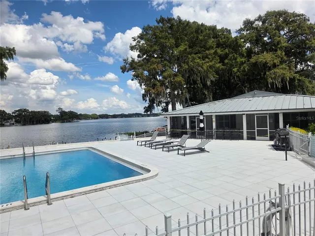 a view of swimming pool with seating space and lake view