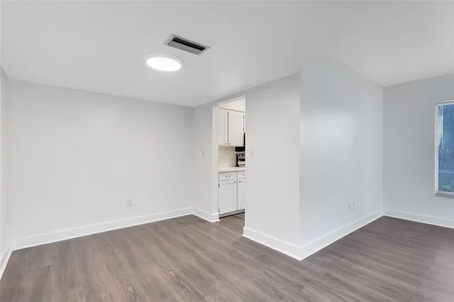 a view of empty room with wooden floor