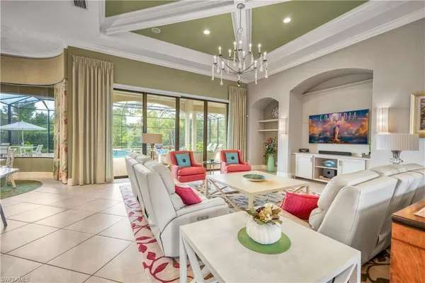 a living room with furniture a chandelier and a dining table