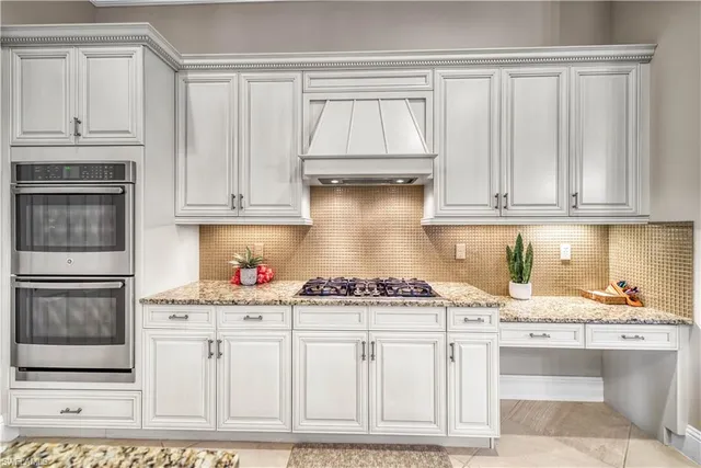 a kitchen with stainless steel appliances granite countertop a stove and cabinets
