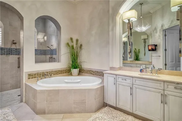 a bathroom with a tub sink and mirror