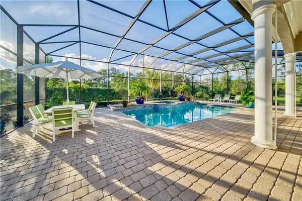 a view of a patio with a table and chairs under an umbrella