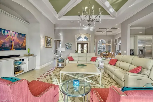 a living room with furniture a chandelier and a dining table