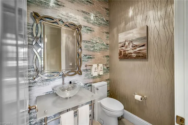 a bathroom with a sink and mirror with toilet