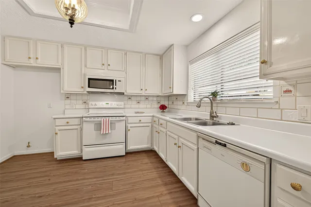 a kitchen with sink a microwave and cabinets