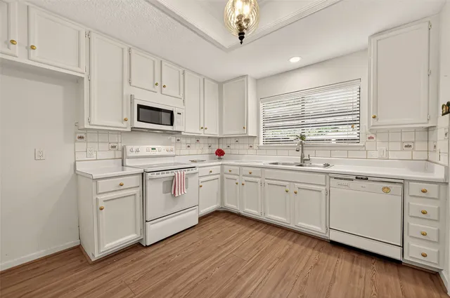 a kitchen with cabinets stainless steel appliances a sink and a window