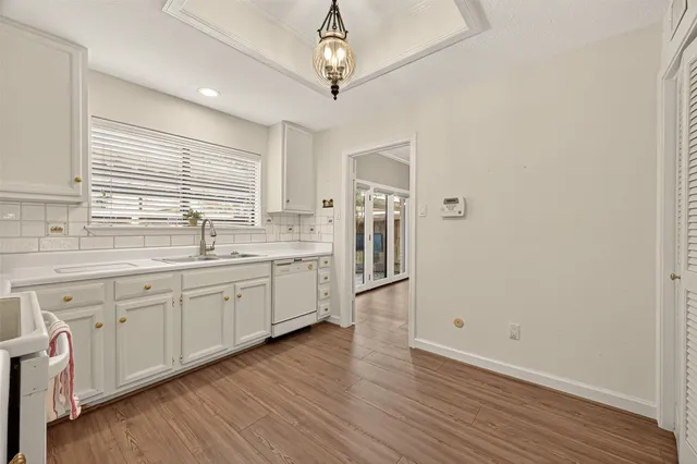a large kitchen with a window and wooden floor