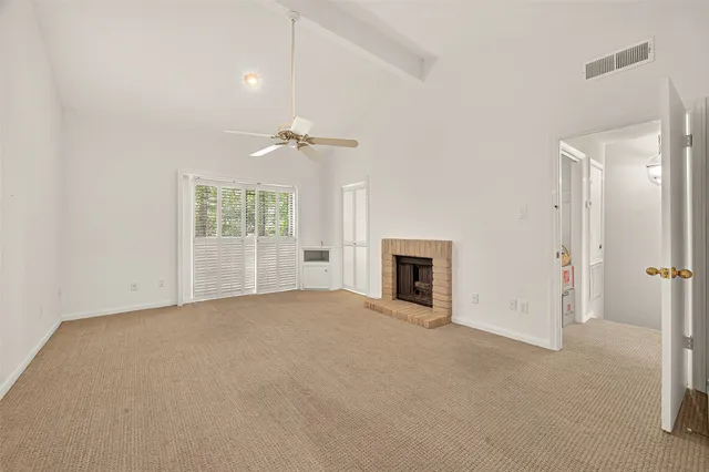 an empty room with windows and fireplace