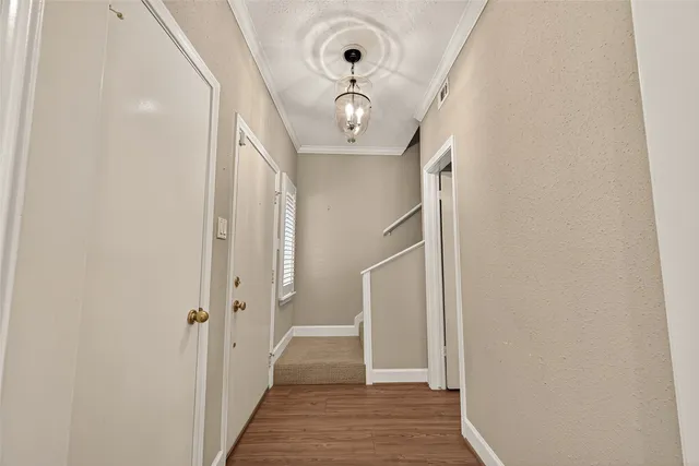 a view of a hallway with wooden floor and entryway