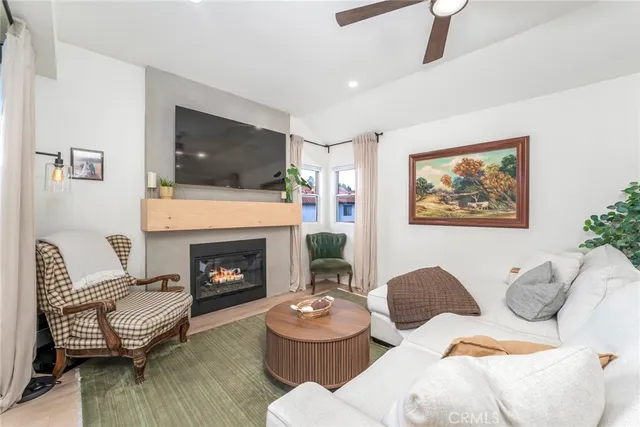 a living room with furniture a flat screen tv and a fireplace