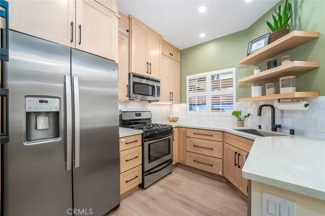 a kitchen with stainless steel appliances a refrigerator sink and microwave