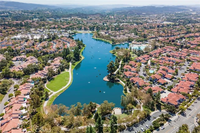 an aerial view of residential houses with outdoor space and trees