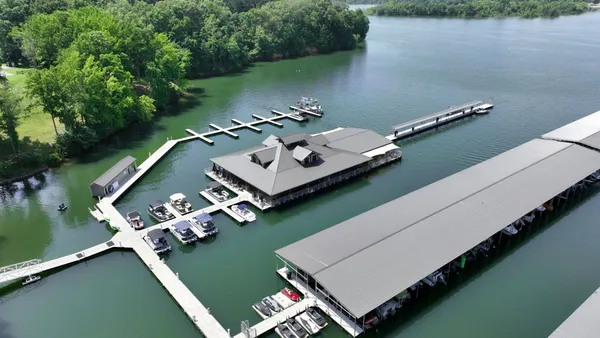 an aerial view of a house with a garden and lake view