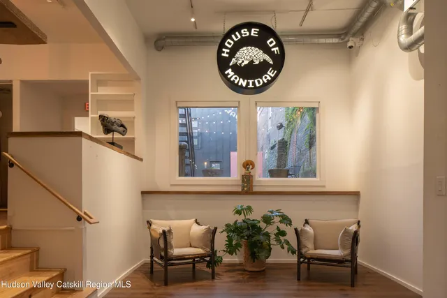 a living room with furniture large window and wooden floor