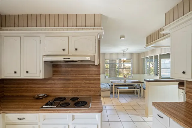 a kitchen with a stove and white cabinets