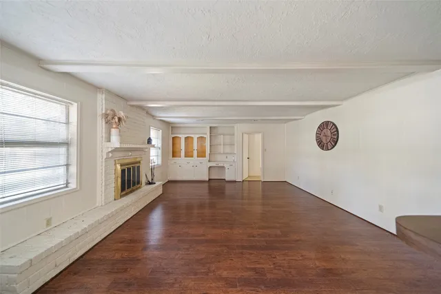 a living room with stainless steel appliances wooden floors and fireplace