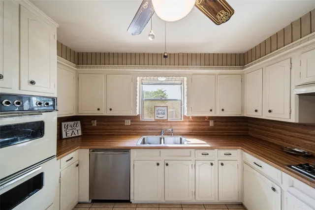 a kitchen with granite countertop white cabinets and white appliances