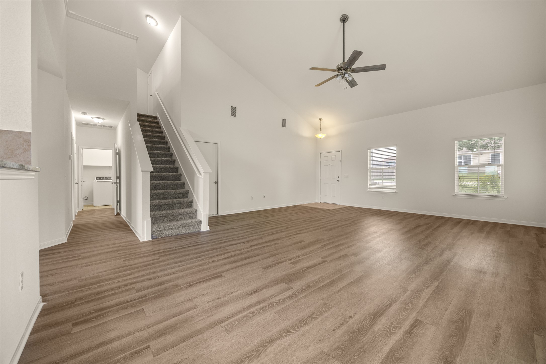 703 Liard River Road Hutto, TX 78634 - Photo 4 of 16 A spacious living area with soaring vaulted ceilings and durable plank flooring.