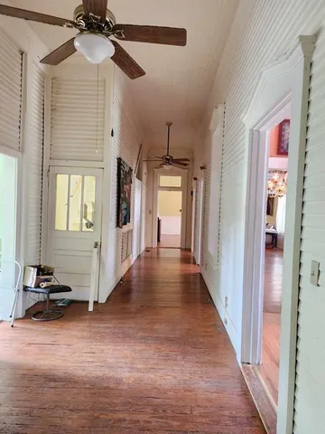 a view of a hallway with entryway wooden floor and front door
