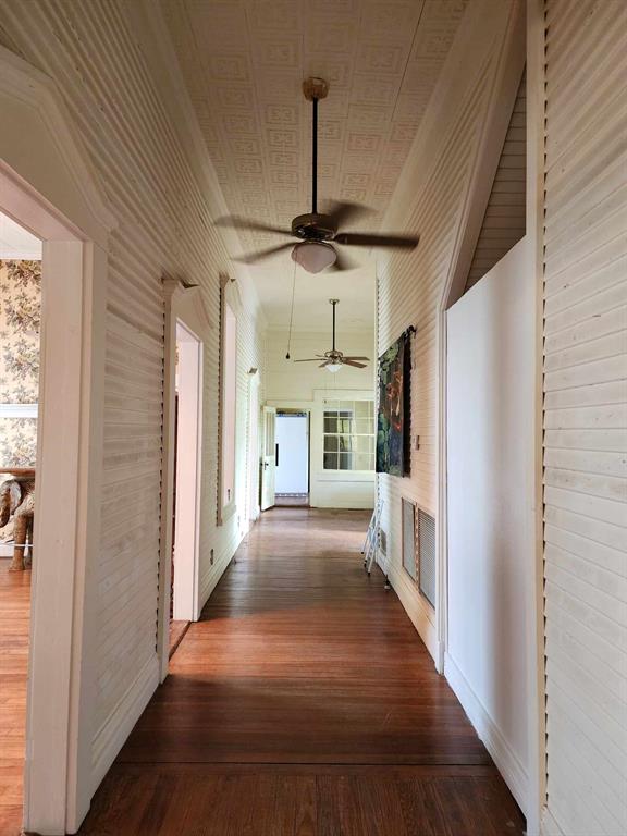 205 South 2nd Street Logansport, LA 71049 - Photo 23 of 36 a view of a hallway to a livingroom with wooden floor a ceiling fan and windows