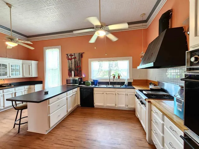 a kitchen with stainless steel appliances kitchen island granite countertop a stove a sink and a microwave