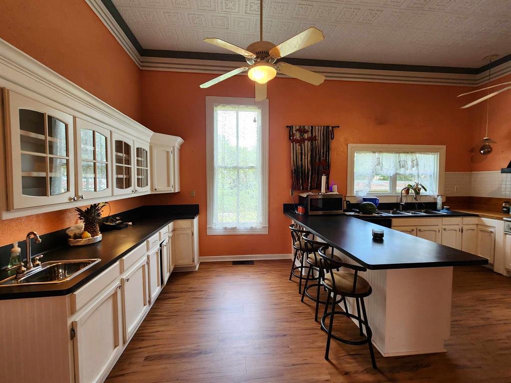 205 South 2nd Street Logansport, LA 71049 - Photo 35 of 36 a kitchen with stainless steel appliances granite countertop a stove a sink dishwasher and a refrigerator with wooden floor