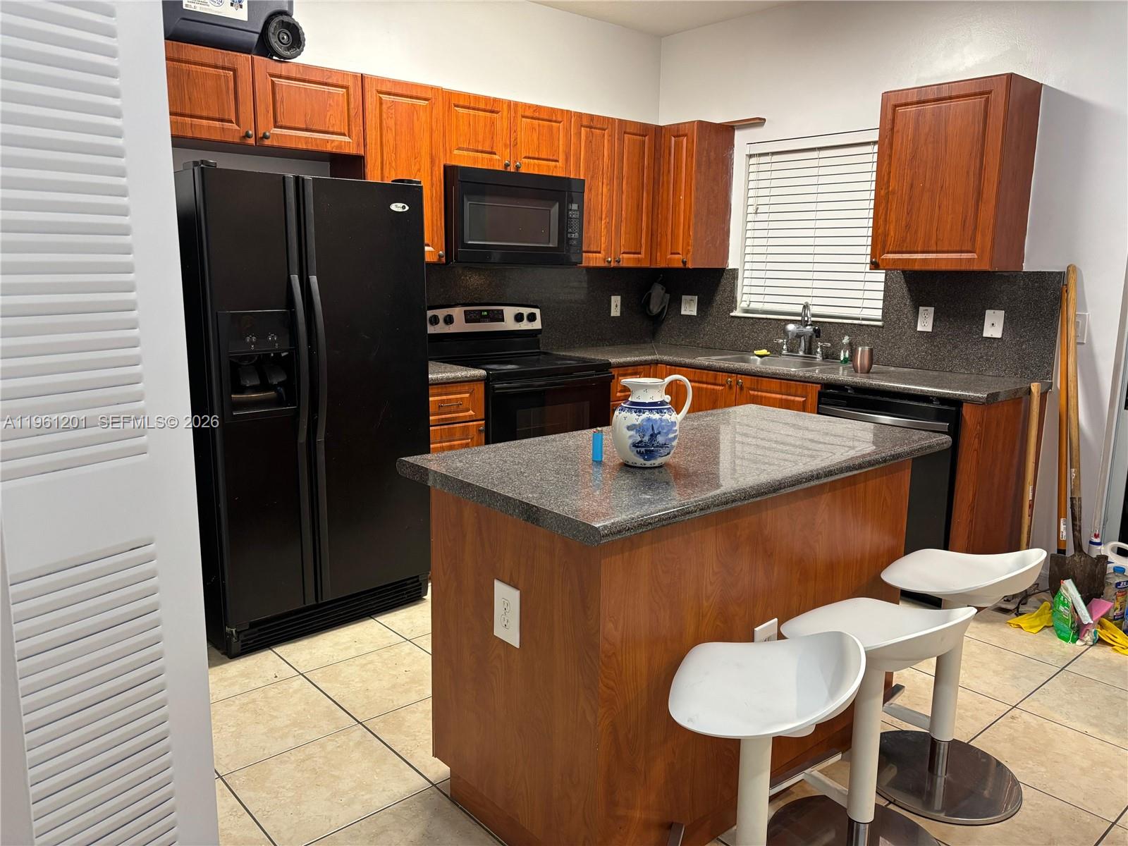 2907 Southeast 15th Terrace Homestead, FL 33035 - Photo 3 of 30 a kitchen with stainless steel appliances granite countertop a sink a microwave refrigerator and chairs