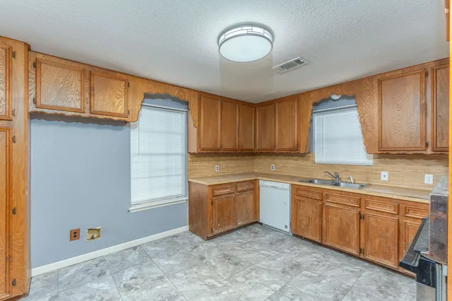a kitchen with a sink window and cabinets