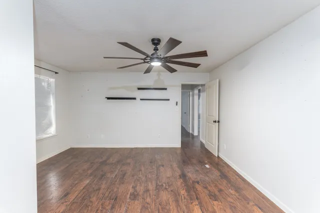a view of an empty room with wooden floor