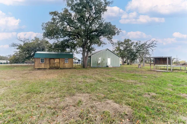 a front view of house with yard and trees in the background