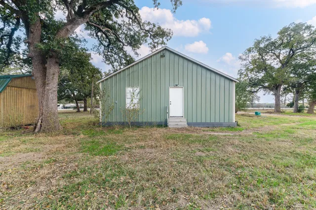 a view of a house with backyard and tree
