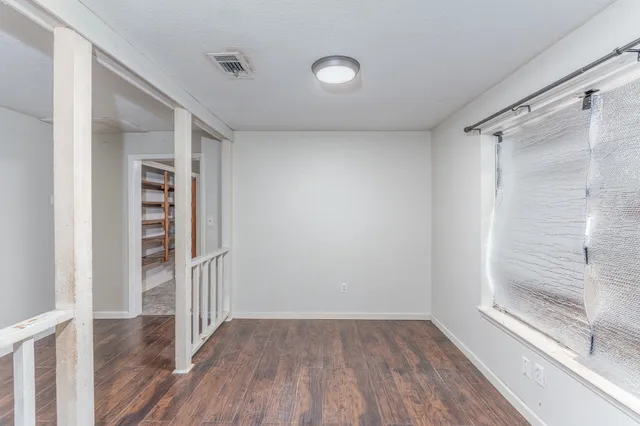 a view of a hallway with wooden floor and closet