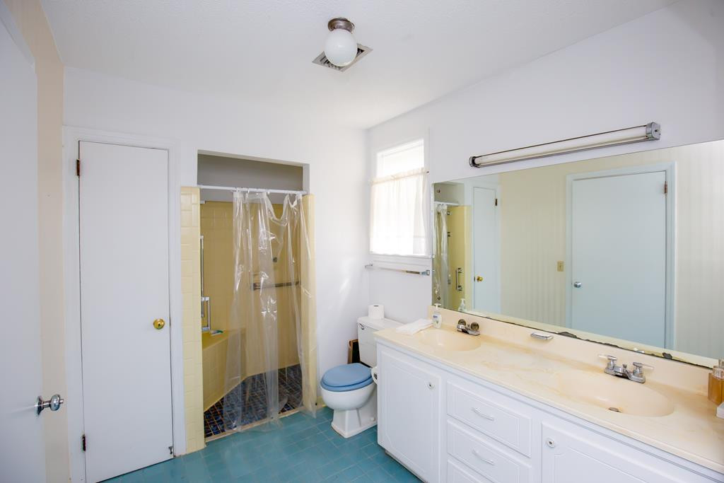 499 Pine Street Bamberg, SC 29003 - Photo 22 of 28 a bathroom with a double vanity sink toilet mirror and shower