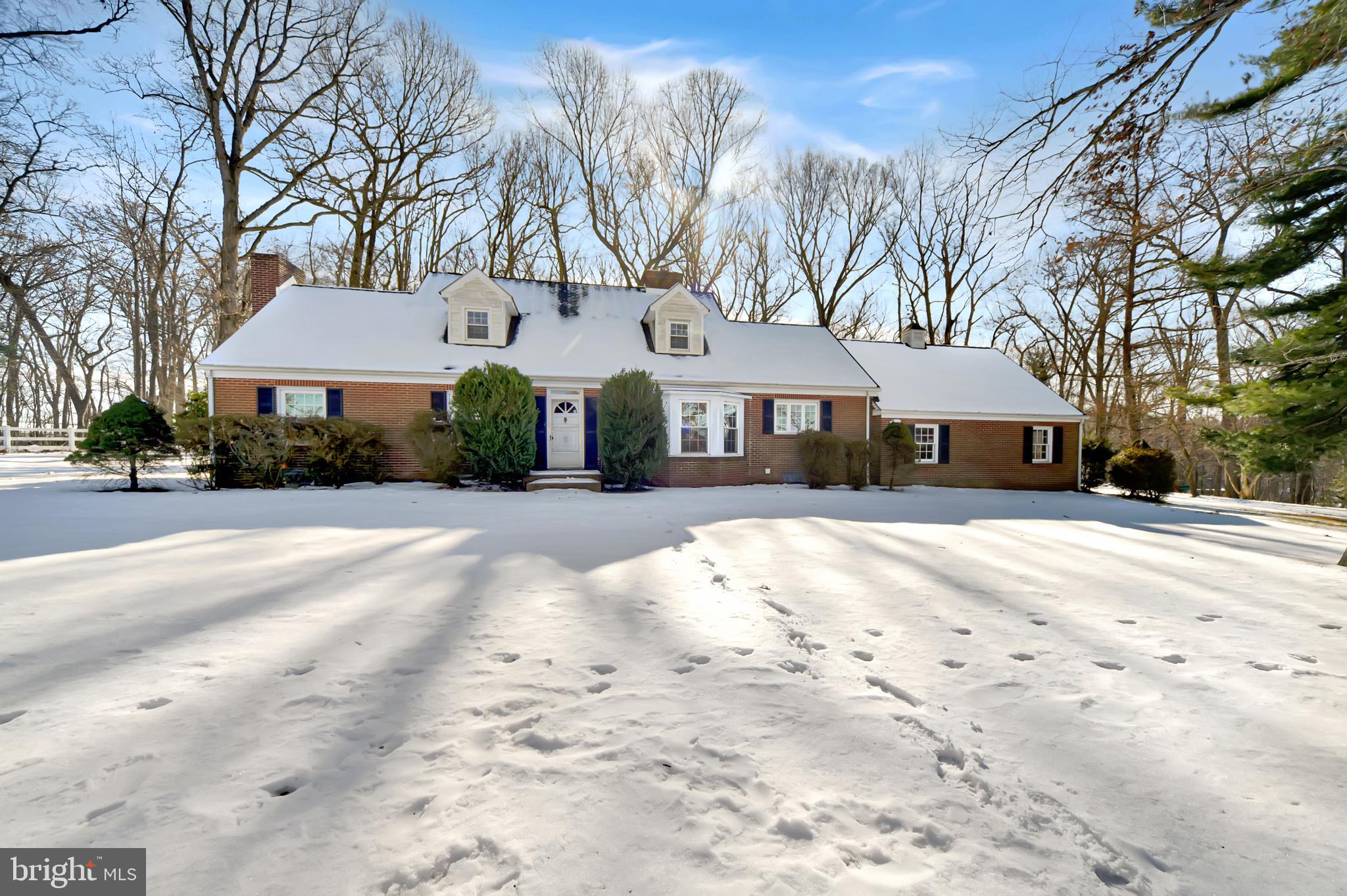 a front view of a house with a yard covered with snow