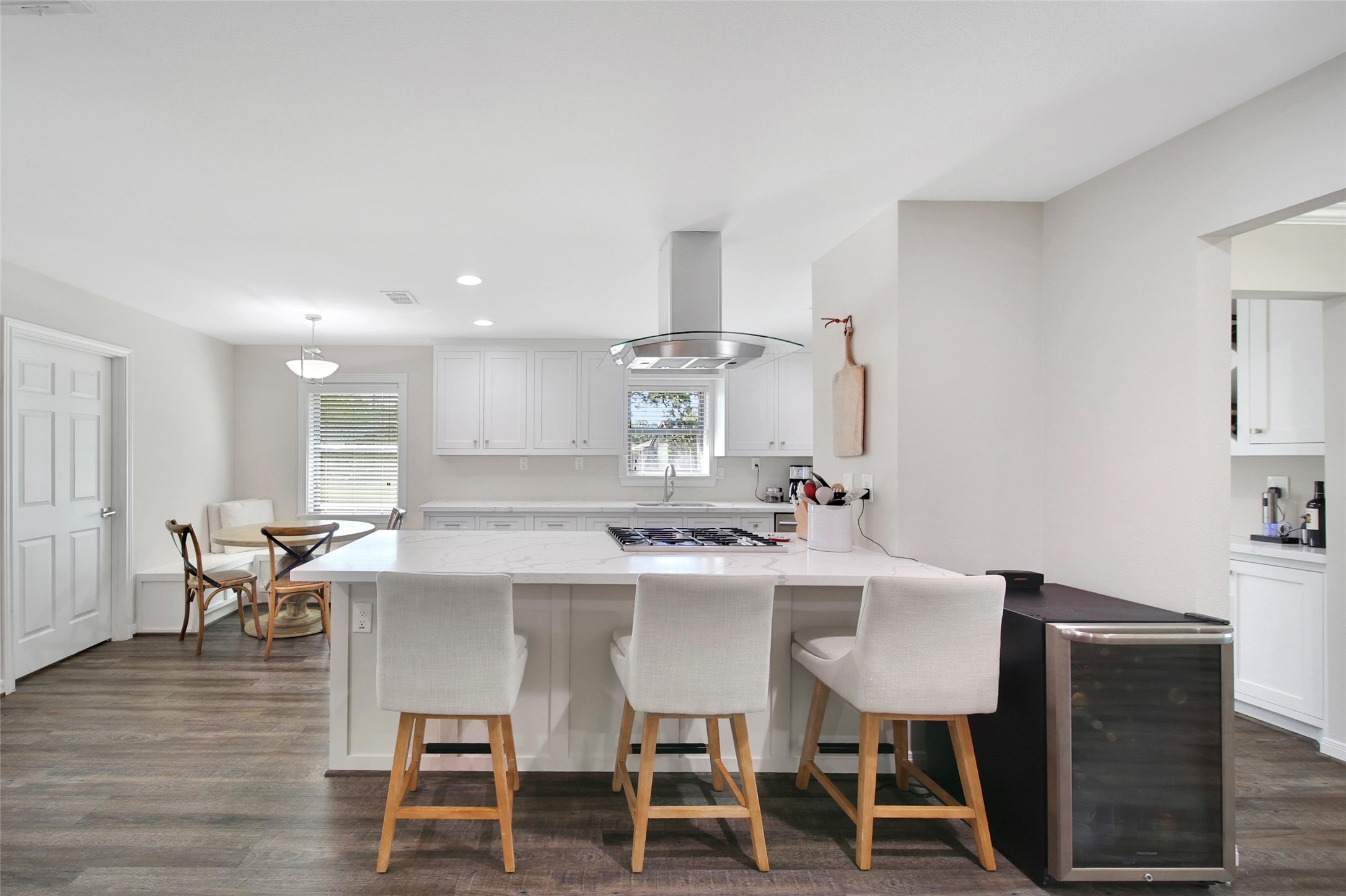 4402 Fallbrook Drive Houston, TX 77018 - Photo 15 of 29 Beautifully updated kitchen featuring a large island with seating, gas cooktop, quartz countertops, and crisp white cabinetry.