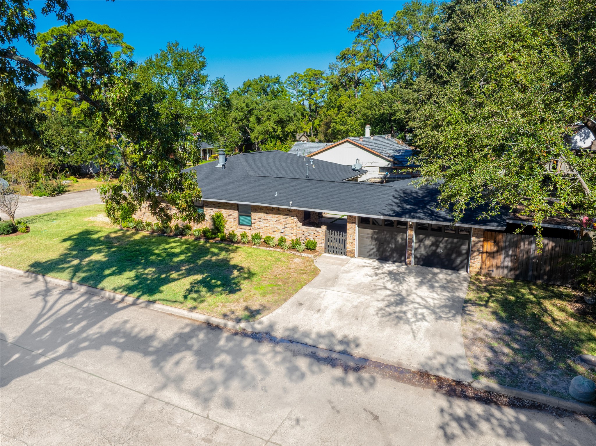4402 Fallbrook Drive Houston, TX 77018 - Photo 5 of 29 Aerial view of the home featuring a wide driveway, updated exterior, and mature tree coverage.