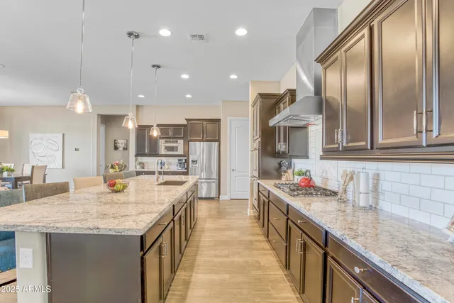 a kitchen with stainless steel appliances granite countertop island wooden cabinets and sink