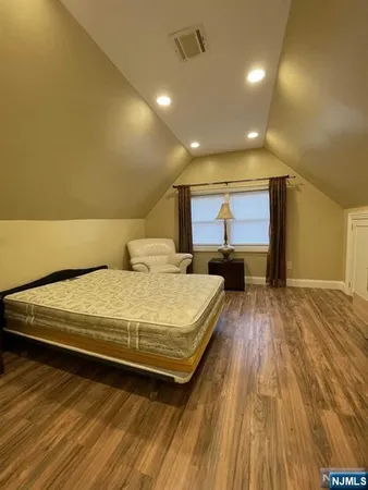 a bed sitting in a spacious bedroom next to a window