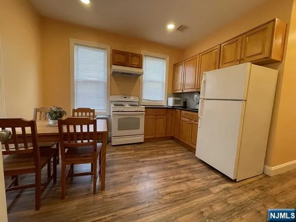a kitchen with granite countertop a refrigerator stove a sink and dishwasher