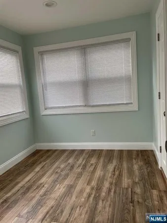 an empty room with wooden floor and a window