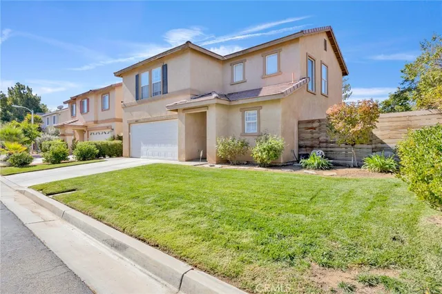 a view of a house with brick walls and a yard with plants
