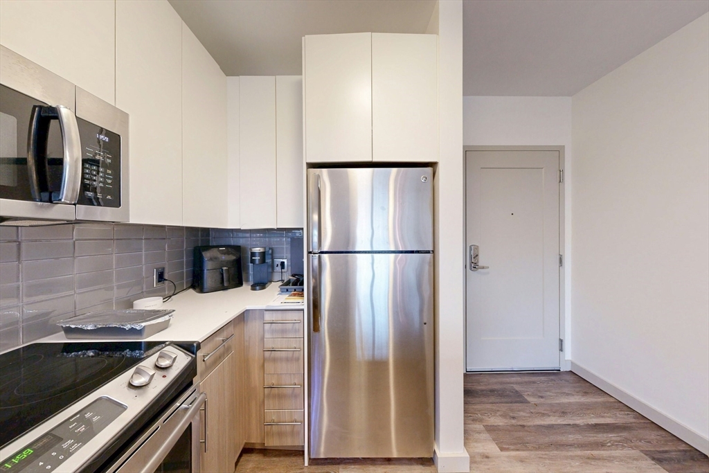 180 Telford Street, Unit 321 Boston, MA 02135 - Photo 5 of 16 a kitchen with a refrigerator and a stove